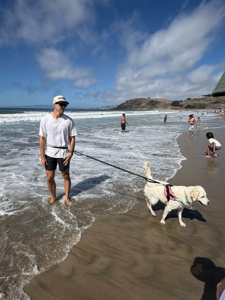 Kristopher walking his golden retriever Muffin on the beach